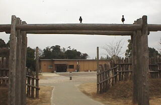 鳥が止まる門（鳥居？）の向こうに見えるのは、吉野ヶ里遺跡展示室